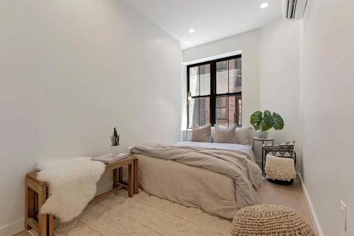 um quarto com uma cama grande e uma janela em Designer Duplex near Central Park em Nova York