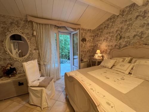 une chambre avec un lit, une chaise et un miroir dans l'établissement villa les iris, à Sernhac