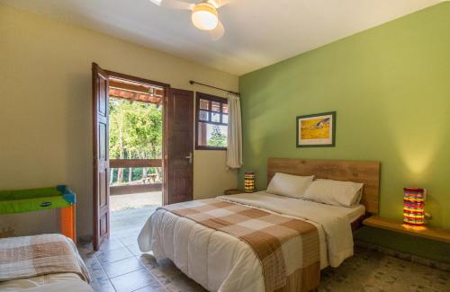 um quarto com paredes verdes, uma cama e uma janela em Hotel Fazenda Canto da Serra em Jaconé