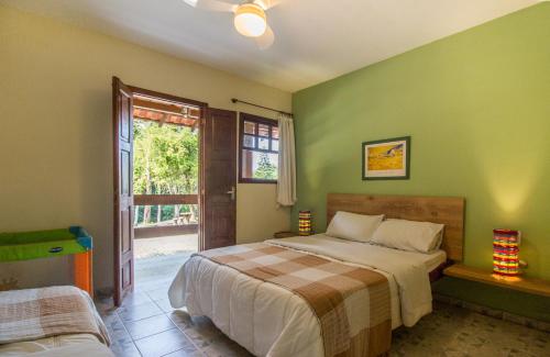 a bedroom with green walls and a bed and a window at Hotel Fazenda Canto da Serra in Jaconé