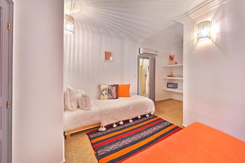una camera bianca con un letto e un tappeto di Riad Amya & Spa a Marrakech