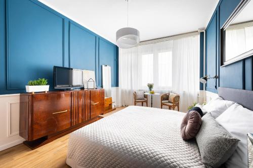 布拉格Bohéme Apartment Wenceslas Square的一间带蓝色墙壁、一张床和电视的卧室
