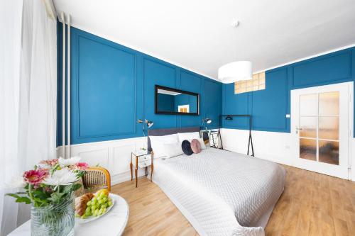 布拉格Bohéme Apartment Wenceslas Square的一间拥有蓝色墙壁的卧室和一张带果盘的床