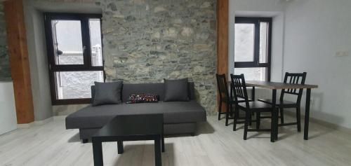 ein Wohnzimmer mit einem Sofa und einem Tisch mit Stühlen in der Unterkunft APARTAMENTO EN EL CASCO HISTÓRICO DE PLENTZIA II in Plentzia