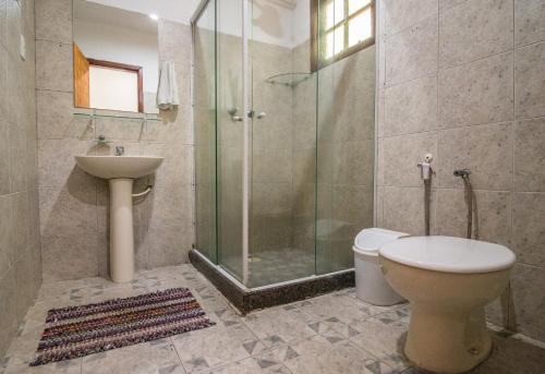 uma casa de banho com um chuveiro, um WC e um lavatório. em Hotel Fazenda Canto da Serra em Jaconé