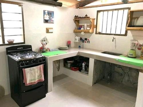 a kitchen with a stove and a counter top at Cabaña Altos de San Carlos in Santa Marta