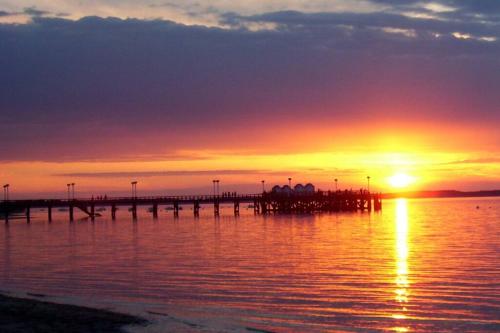 une jetée au coucher du soleil sur l'eau dans l'établissement Studio cosy à Arcachon pour 2 personnes, à Arcachon