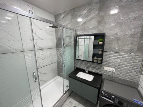 een badkamer met een douche, een wastafel en een bad bij Yakkasaroy Dream House in Tasjkent