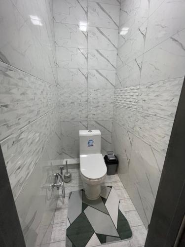 La salle de bains blanche est pourvue de toilettes. dans l'établissement Yakkasaroy Dream House, à Tachkent