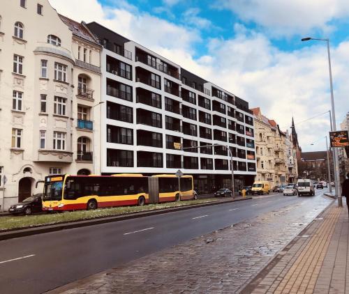 a bus parked in front of a building on a street at Apartament No1 Wyszyńskiego in Wrocław