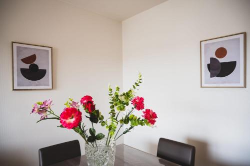 un vase rempli de fleurs posé sur une table dans l'établissement L'Orée des Bois - at the gates of the Old Town, à Annecy