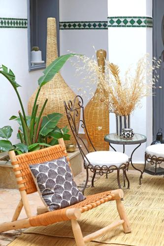 a room with chairs and tables and plants at Riad Amya & Spa in Marrakech