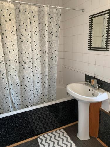 a bathroom with a shower curtain and a sink at 16 Main Street in St Bees