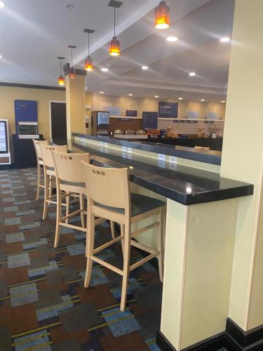 a restaurant with a bar with chairs around it at Holiday Inn Express and Suites Detroit North-Troy by IHG in Troy