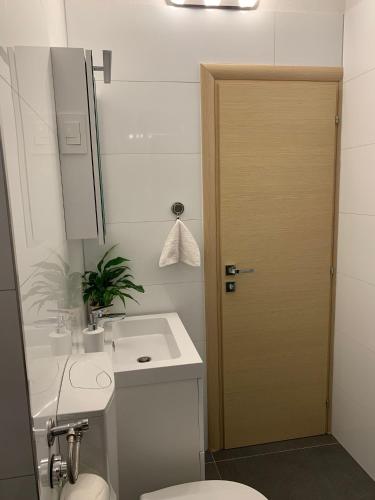 a bathroom with a toilet and a sink and a door at MM Split apartment - 5 min by car to the beach & city center - free public parking in Split