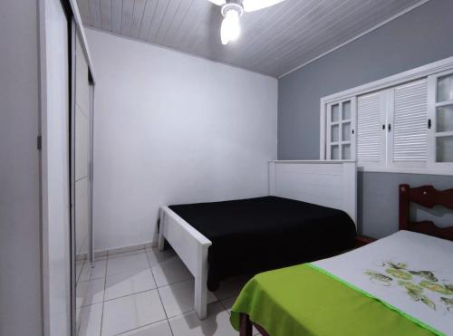 a bedroom with two beds in a room with blue walls at Casa individual aconchegante - Rio da praia - Bertioga in Bertioga