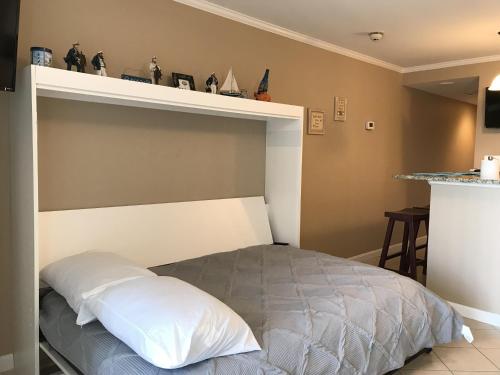 um quarto com uma cama com uma prateleira por cima em Makai 403 em Ocean City