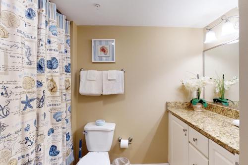 a bathroom with a toilet and a shower curtain at Makai 403 in Ocean City