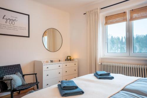 Schlafzimmer mit einem Bett, einem Spiegel und einem Fenster in der Unterkunft Hygge House Bled in Bled