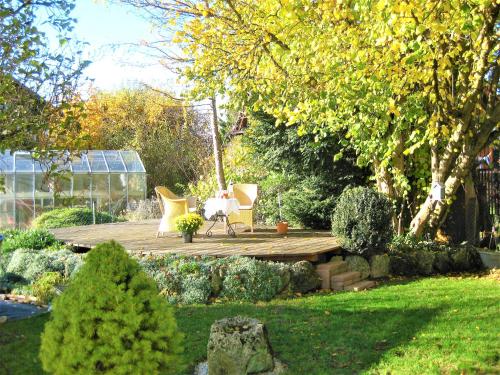 a garden with chairs and a wooden deck at komf.Ferienwohnung Elisabeth (1.Stock) in Weilheim, m.Garten, zwischen München u. Garmisch-P. in Weilheim in Oberbayern
