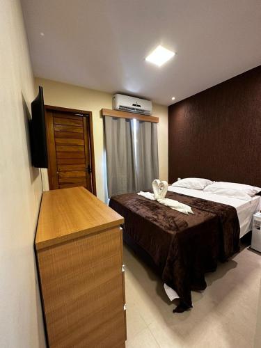 um quarto de hotel com uma cama e uma cómoda em Pousada Vento Solar Búzios em Búzios