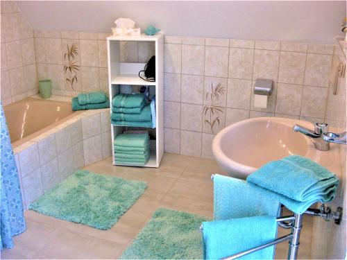 a bathroom with a sink and a tub with towels at komf.Ferienwohnung Elisabeth (1.Stock) in Weilheim, m.Garten, zwischen München u. Garmisch-P. in Weilheim in Oberbayern