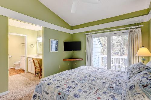 1 dormitorio con paredes verdes, 1 cama y ventana en Egrets Pointe, Unit 492, en Edisto