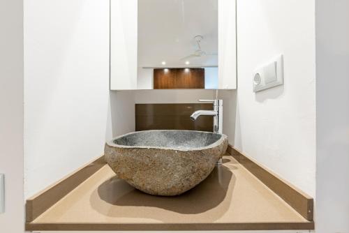 a bathroom with a large rock bowl on the floor at Loft Planta Baja en Barri Port Maritim in Tarragona