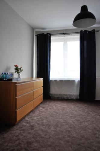 a room with a dresser and a large window at Apartament Śródmieście Krosno in Krosno