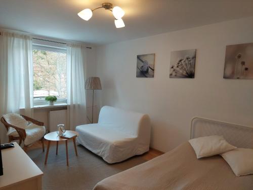 - une chambre avec un lit, une chaise et une fenêtre dans l'établissement Apartament Opera, à Sopot
