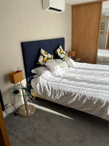 a bedroom with a large bed with a blue headboard at Sea breeze Exmouth in Lympstone