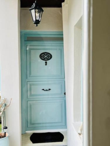 a blue cabinet in a hallway with a light blue door at Grandma’s stone-house in Amfilochía