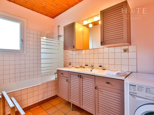 Un baño con lavabo y lavadora. en Le petit havre de paix Longevillai, en Longeville-sur-Mer