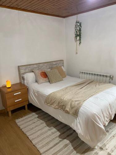 um quarto com uma cama grande e uma mesa de cabeceira em Casa de campo a 5 min de Vigo em Mos