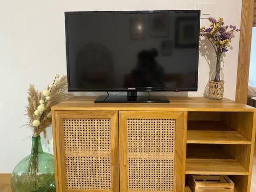a television sitting on top of a wooden entertainment center at Casa de campo a 5 min de Vigo in Mos