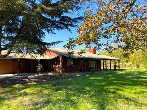 uma casa com um grande quintal em frente em Calera de Tango Chena Magica em Maipú