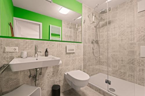 un bagno con wc, lavandino e doccia di Farbenfrohe Altbauwohnung, TOP Ausstattung (Klima) a Friedrichshafen