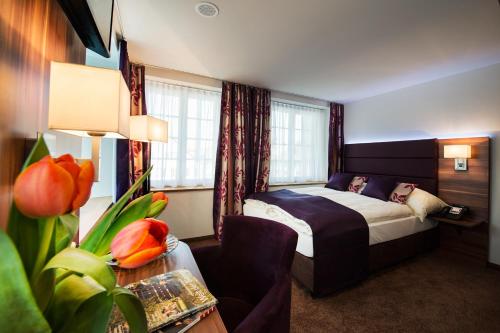 ein Hotelzimmer mit einem Bett mit einer Frau auf dem Bett in der Unterkunft Gasthof zum Hecht in Fehraltorf