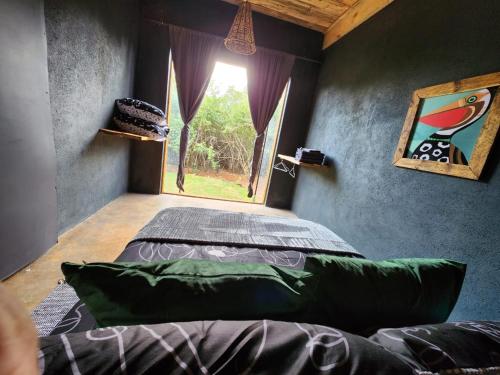 a bedroom with a bed in a room with a window at Hartbeest eco bush lodge 2 in Hartbeespoort