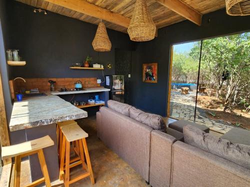 a living room with a couch and a large window at Hartbeest eco bush lodge 2 in Hartbeespoort