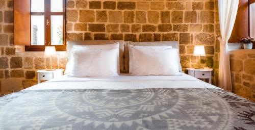a bedroom with a large bed with two lamps at Mandorla Apartments in Rhodes Town