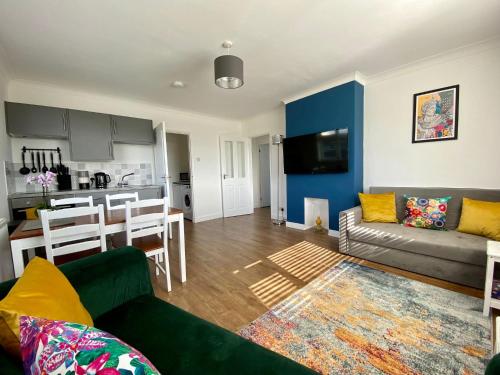 a living room with a couch and a kitchen at Cairo House in Peacehaven