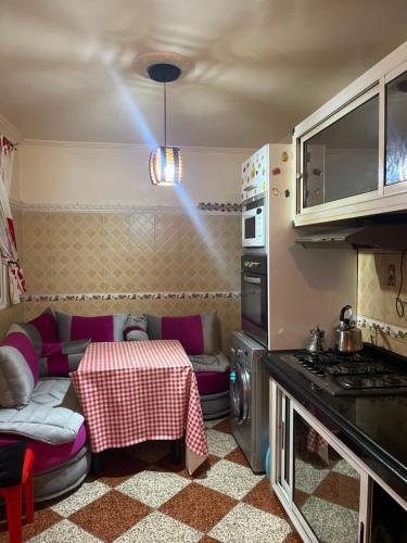 uma pequena cozinha com uma mesa e um sofá em Elegant traditional appartement em El Jadida