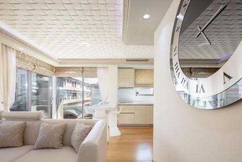a living room with a white couch and a mirror at De President Suite, DeMaNi President Suites in Sitia