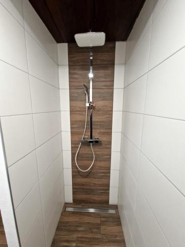 a shower in a bathroom with white tiles at Ferienhaus Kleissner in Nestelberg