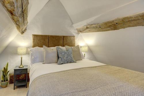 1 dormitorio con 1 cama blanca grande con almohadas en Loft Cottage by Spa Town Property - 2 Bed Tudor Retreat Near to Stratford-upon-Avon, Warwick & Solihull, en Stratford-upon-Avon