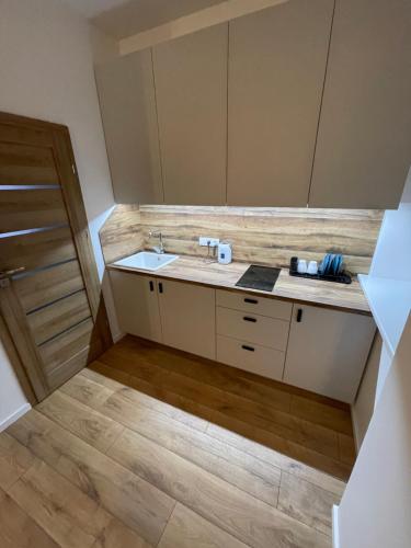 a bathroom with a sink and a wooden floor at Airport Apartment 32 self check-In Free Parking in Vilnius