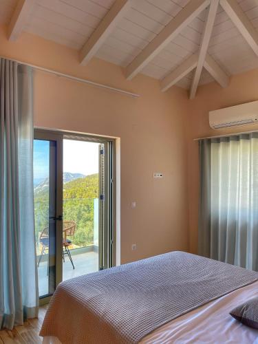 a bedroom with a bed and a sliding glass door at Selene houses in Athanion