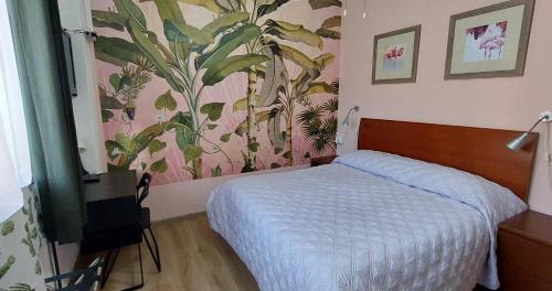a bedroom with a bed and a painting on the wall at Villa La Lanterna in Pietra Ligure