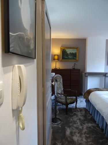 a hotel room with a phone on the wall at Chambres et Table d'hôtes La Belle Lensoise in Lens